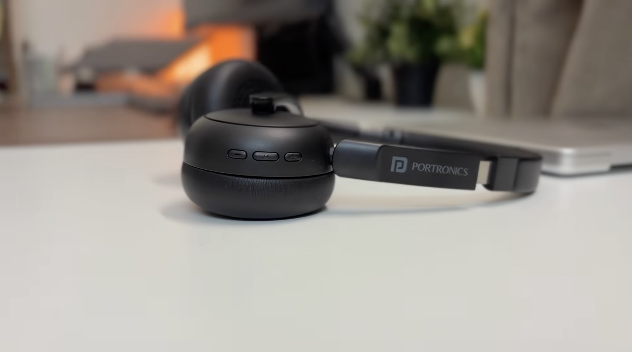 Portronics Muffs A3 left earcup — three control buttons and boom arm with mute button visible